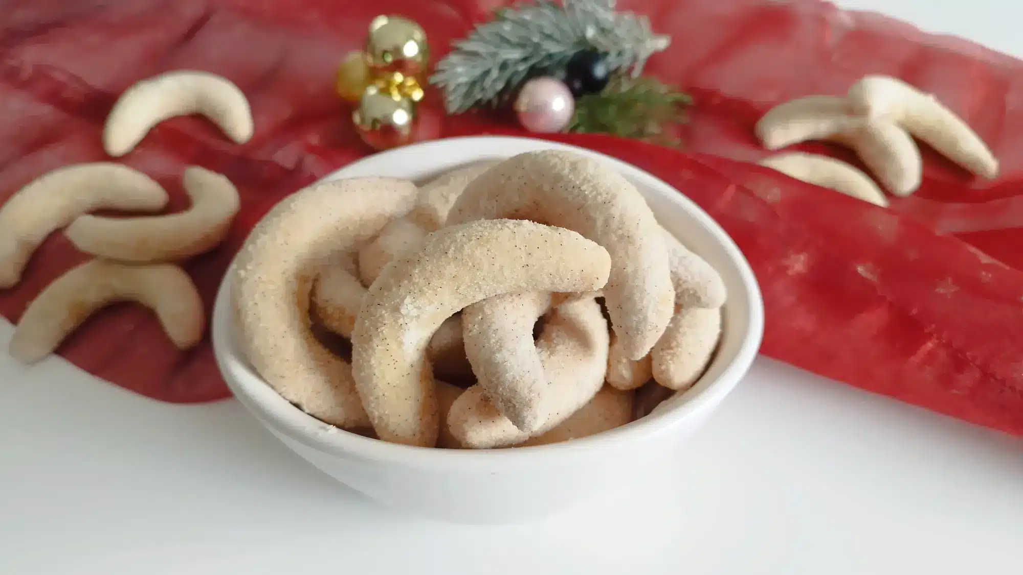 Traditionelle Weihnachtsplätzchen: Vanillekiperl in einer Schale mit weihnachtlicher Dekoration