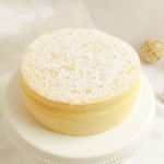 Japanischer Cheesecake auf einem Tortenteller mit Puderzucker bestäubt